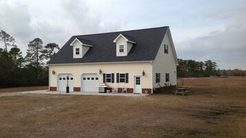 A two-story house with a gabled roof, a front porch, and a garage.
