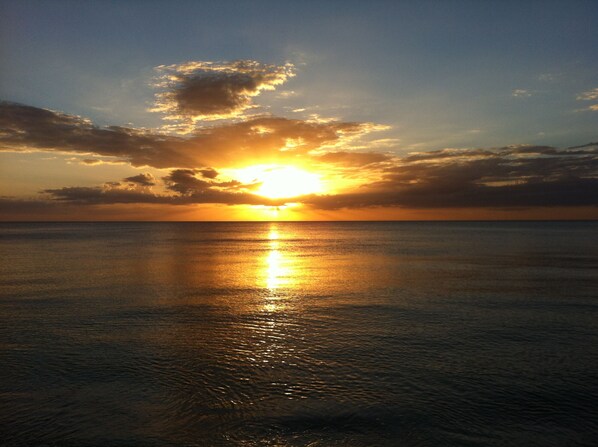 A sunset over a calm sea with a clear horizon.