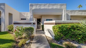 A modern building with a concrete facade, a central entrance, and a pathway leading to the door. - Desert Princess Cc And Resort, On Golf Course, W/ Mountain Views (Cathedral City)