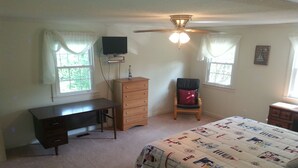 A bedroom with a bed, a desk, a chair, a dresser, a ceiling fan, and a TV mounted on the wall. - Relatively Secluded Location Yet Only 10 Minute Drive To Pubs And Restaurants. (Chocowinity)