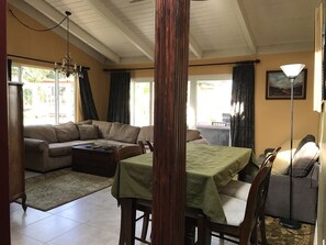 A living room with a sofa, a dining table, and a lamp.