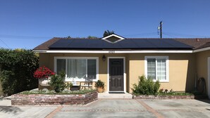 A single-story house with a dark roof, beige walls, and a brick front. - Private Guest Unit with backyard, Home away from home! (Santa Ana)