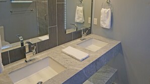A modern bathroom with two sinks, a large mirror, and built-in towel racks. - Fun Guest Quarter With Bathroom Available For Rent Close To Downtown Bend. (Bend)