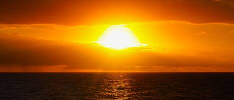 Ein Sonnenuntergang über dem Meer bei klarem Himmel.