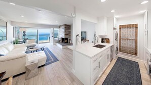 A modern kitchen with a central island, white cabinetry, and a view to the sea. - Spectacular Oceanfront  - the Best Views in Dana Point !!!!! (Dana Point)