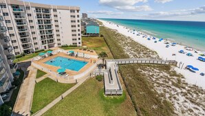 A high-rise hotel with a swimming pool, beach access, and a view of the ocean.