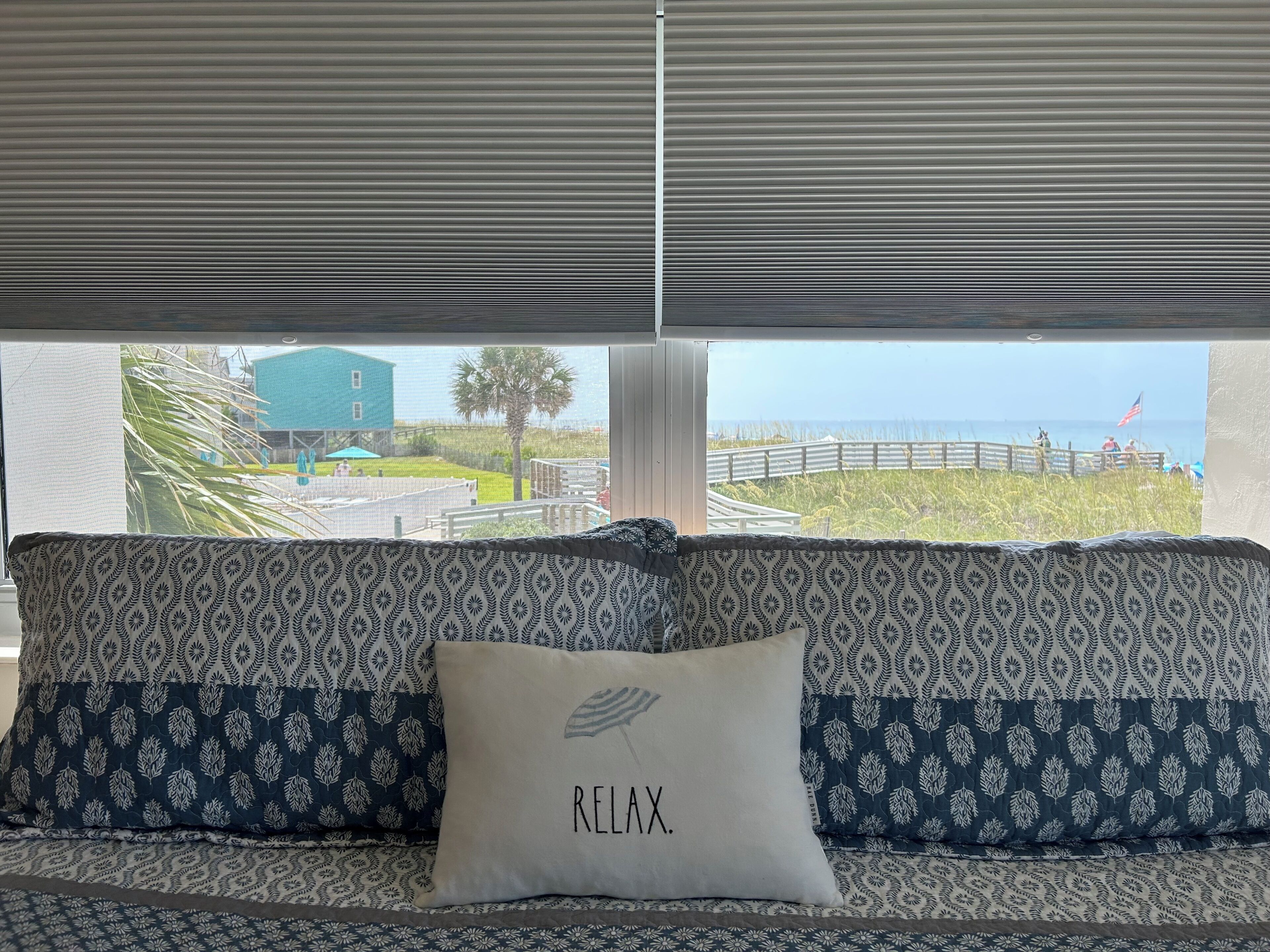 A room with a view of a beach and a building.