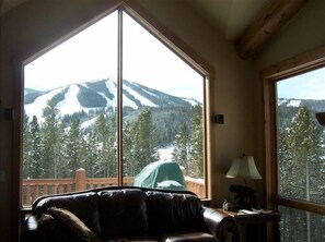Relax in this serene space with a leather sofa and stunning mountain views through the large window.