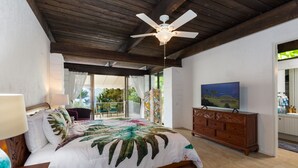 A bedroom with a bed, a wooden dresser, a television, and a ceiling fan. - Private Oceanview Oasis w/Pool, Spacious Lanai, & Stunning Sunsets: Ono Oasis (Kailua Kona)