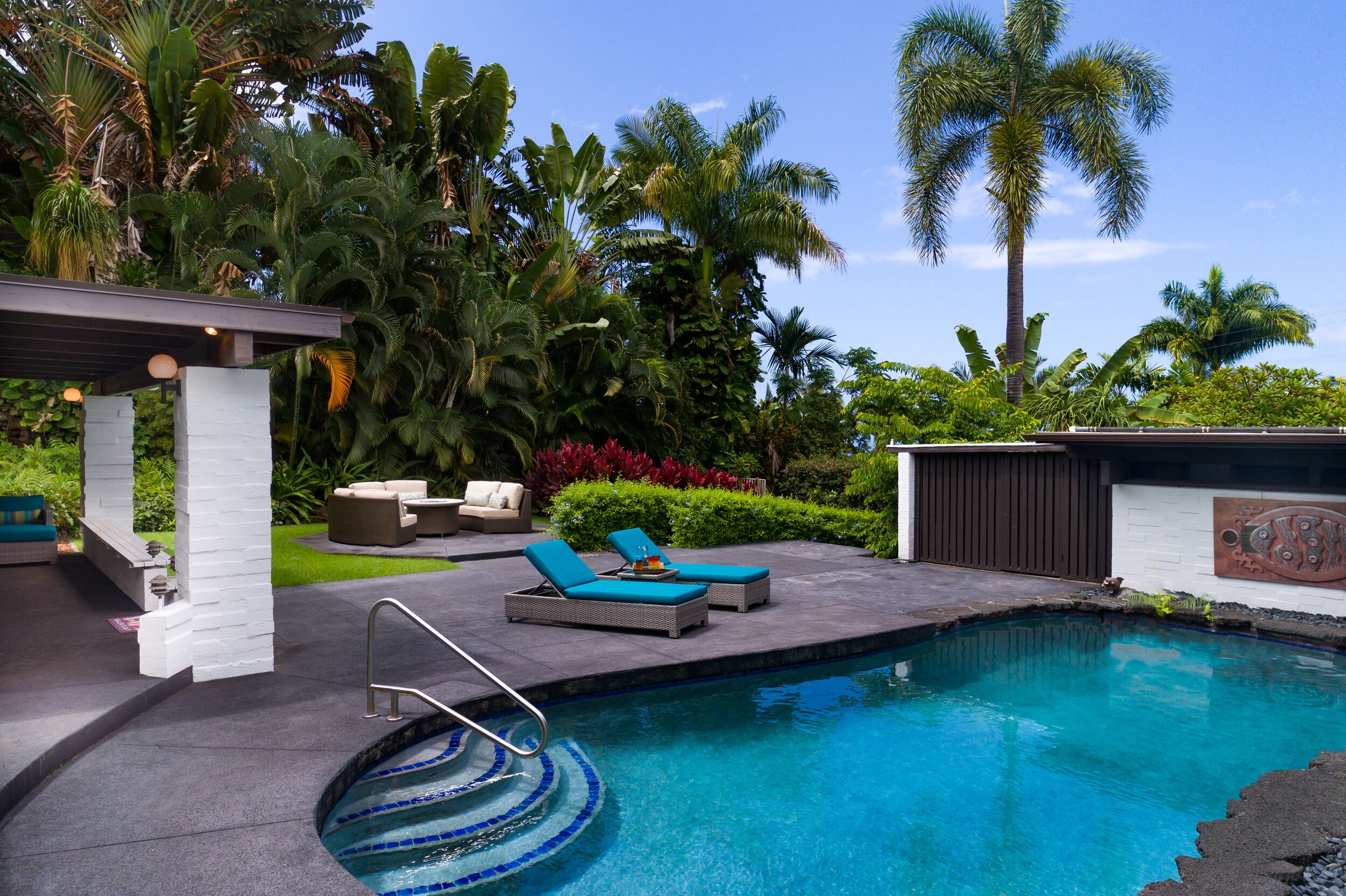 A pool area with lounge chairs and a hot tub.