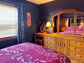 A bedroom with a bed, dresser, mirror, lamp, and window with blinds. - Magog Lovely holiday home (Magog)