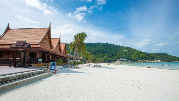 A beach with a traditional building with a tiled roof and a staircase leading to the beach. - Apartment By Sunrise Resort (Ko Pha-ngan)