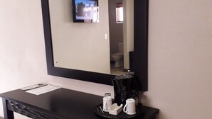 A hotel room with a large mirror, a coffee station, and a small seating area. - Coyotes Hotel and Conference Centre (Mbombela)
