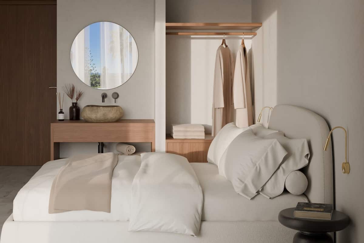 Quarto moderno com uma cama, um espelho redondo, uma mesinha de vaidade com pia e uma mesa de cabeceira com um livro.