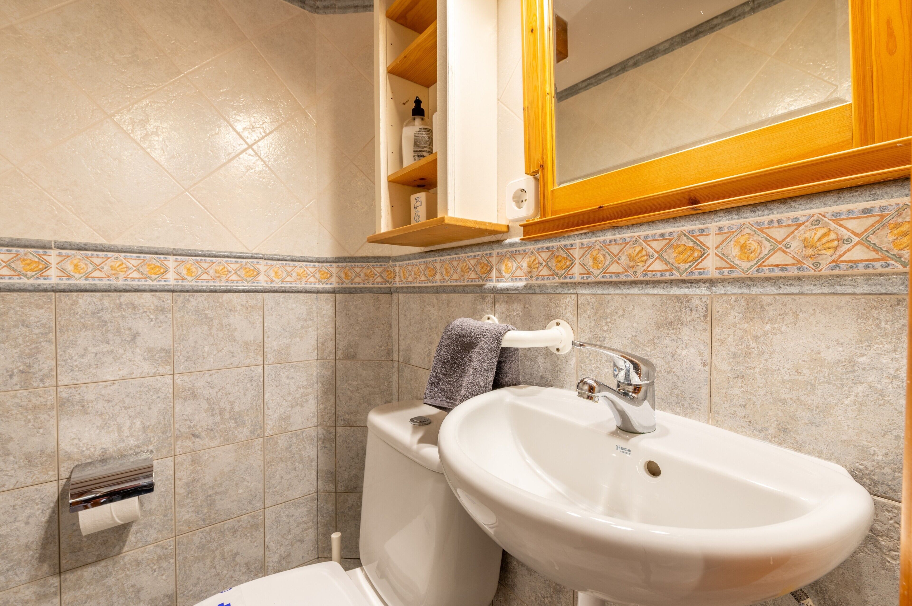 Un bagno con il water, un lavandino e un portasciugamani.