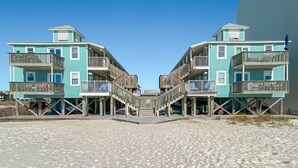 A beachfront property with two-story buildings featuring balconies and wooden decks. - Sunrise Village 201 - Private balcony right on the (Gulf Shores)
