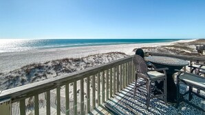 A beach view from a wooden deck with a table and chairs. - Sunrise Village 201 - Private balcony right on the (Gulf Shores)