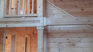 Une cabane en bois avec un balcon et un escalier.