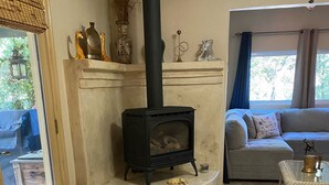 Una sala de estar acogedora con chimenea, un sofá, una mesita de centro y una alfombra.