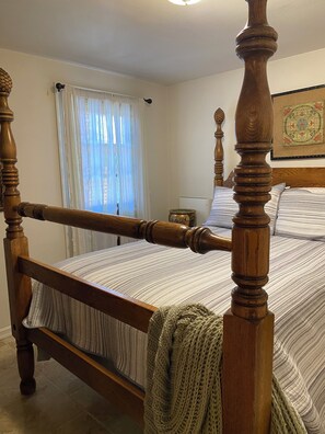 A four-poster bed with a wooden frame and striped bedding, a window with sheer curtains, and a framed picture on the wall. - Enjoy a Slice Of Country--Two miles to Downtown Healdsburg  (Healdsburg)