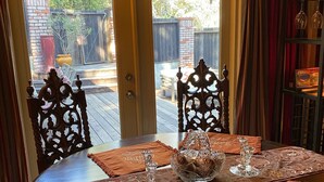 Mesa vestida con individuales, cristalería y un centro de mesa decorativo.