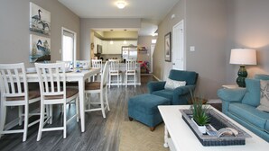 Un vaste espace de vie comprenant une table à manger, des chaises et un canapé bleu.