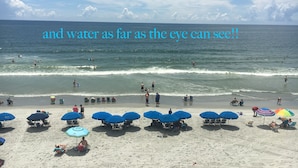 A beach with umbrellas and people enjoying the water. - Beachfront/Pool Murrells/GardenCity/Surfside 
Wkly/MilitaryFirePoliceNurse Discs (Murrells Inlet)