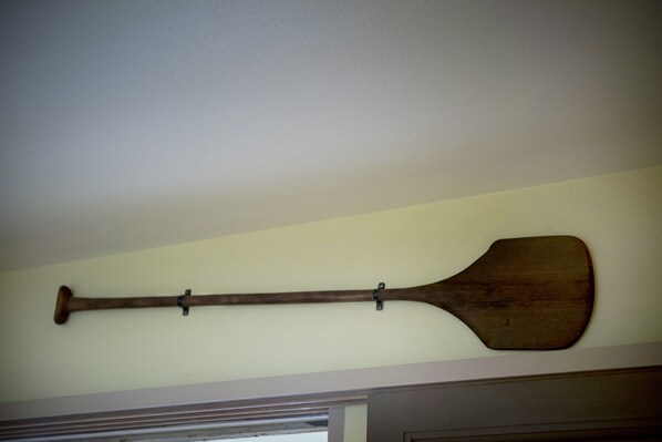 A wooden paddle hanging on a wall.