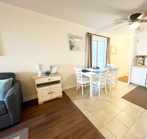 Un espacio habitable compacto con comedor, kitchenette y sofá.