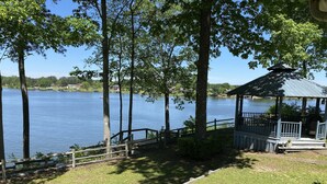 A lakeside gazebo with a wooden deck and a view of the lake.