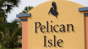Ein Schild mit dem Schriftzug 'Pelican Isle' und einer Vogelkontur.