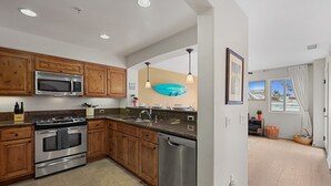 Una cocina moderna con armarios de madera, electrodomésticos de acero inoxidable y un amplio ventanal con vistas al exterior.