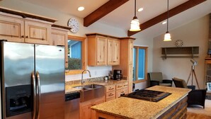 Una cocina moderna con armarios de madera, electrodomésticos de acero inoxidable, encimeras de granito y una isla grande.