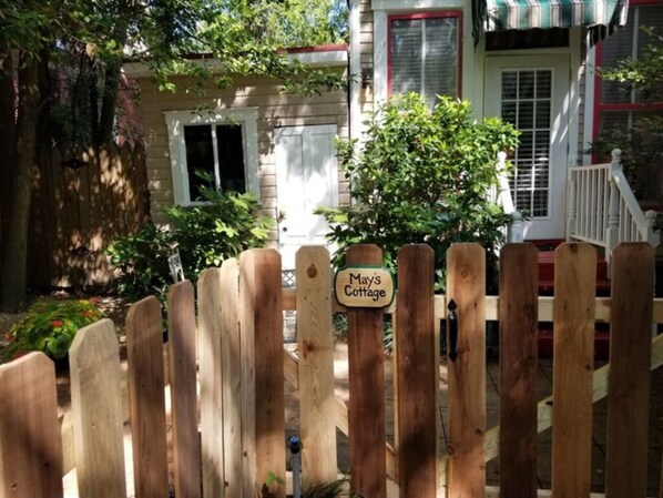 Ein Holzzaun mit einem Schild, auf dem 'Mays Cottage' steht.