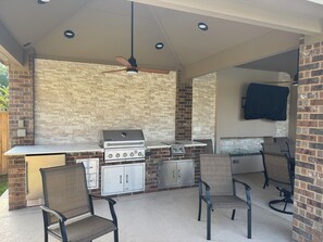 An outdoor kitchen with a grill, stove, and seating area. - Nice Family Fr. WalMart and HEB & Wallgreens Walking, Iron Man. 3 Nights Minimum (The Woodlands)