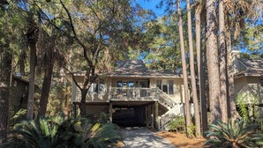 A two-story house with a covered porch and a garage. - Pet-Friendly 3BR Inlet Cove Cottage - Walk to Beach, Pool & Kiawah River (Johns Island)