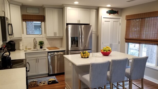 A modern kitchen with white cabinets, stainless steel appliances, and a central island with chairs. - Pet-Friendly 3BR Inlet Cove Cottage - Walk to Beach, Pool & Kiawah River (Johns Island)