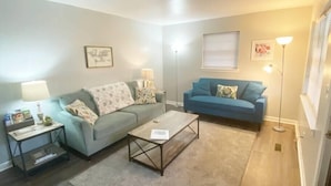 A living room with a sofa, a coffee table, a lamp, and a floor lamp.