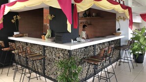 Un café con pared de piedra, una barra y taburetes.