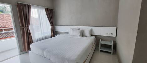 A modern bedroom with a large bed, a nightstand, and a headboard with built-in lighting.