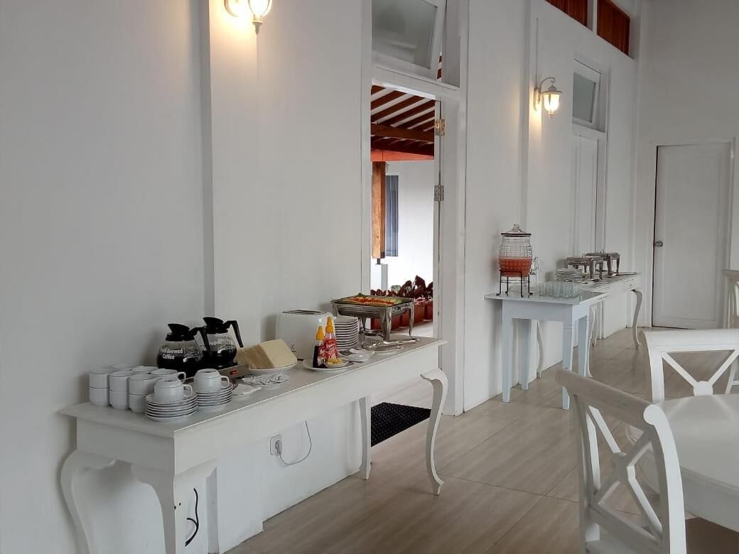 A breakfast bar with white furniture and a buffet setup.