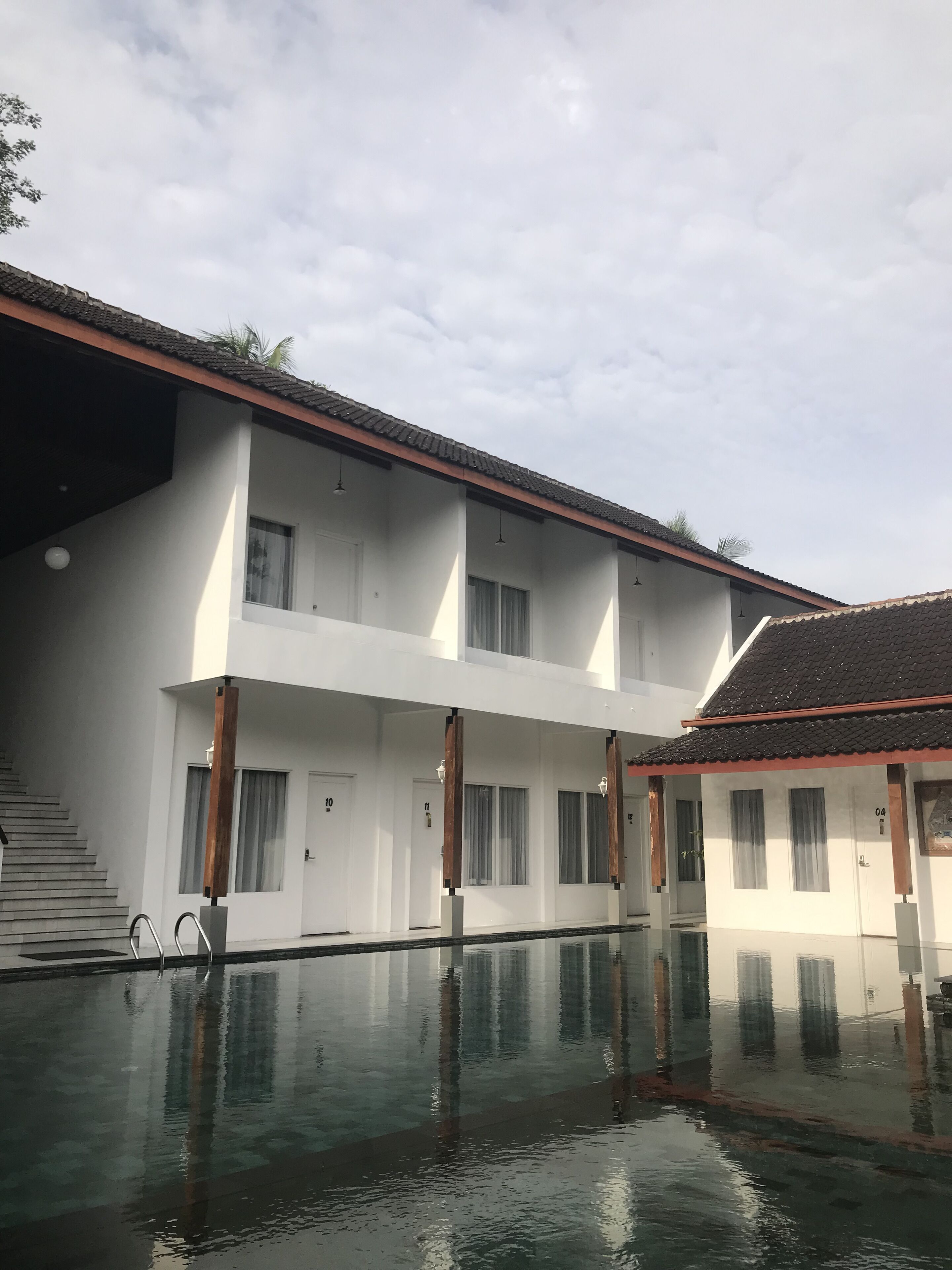 Un bâtiment à deux étages avec une piscine devant.