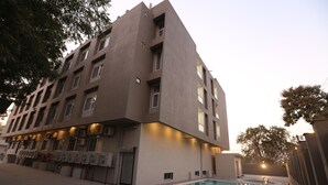 A modern building with a swimming pool, multiple windows, and a flat roof. - Kukda Resort Chittorgarh (Chittorgarh)