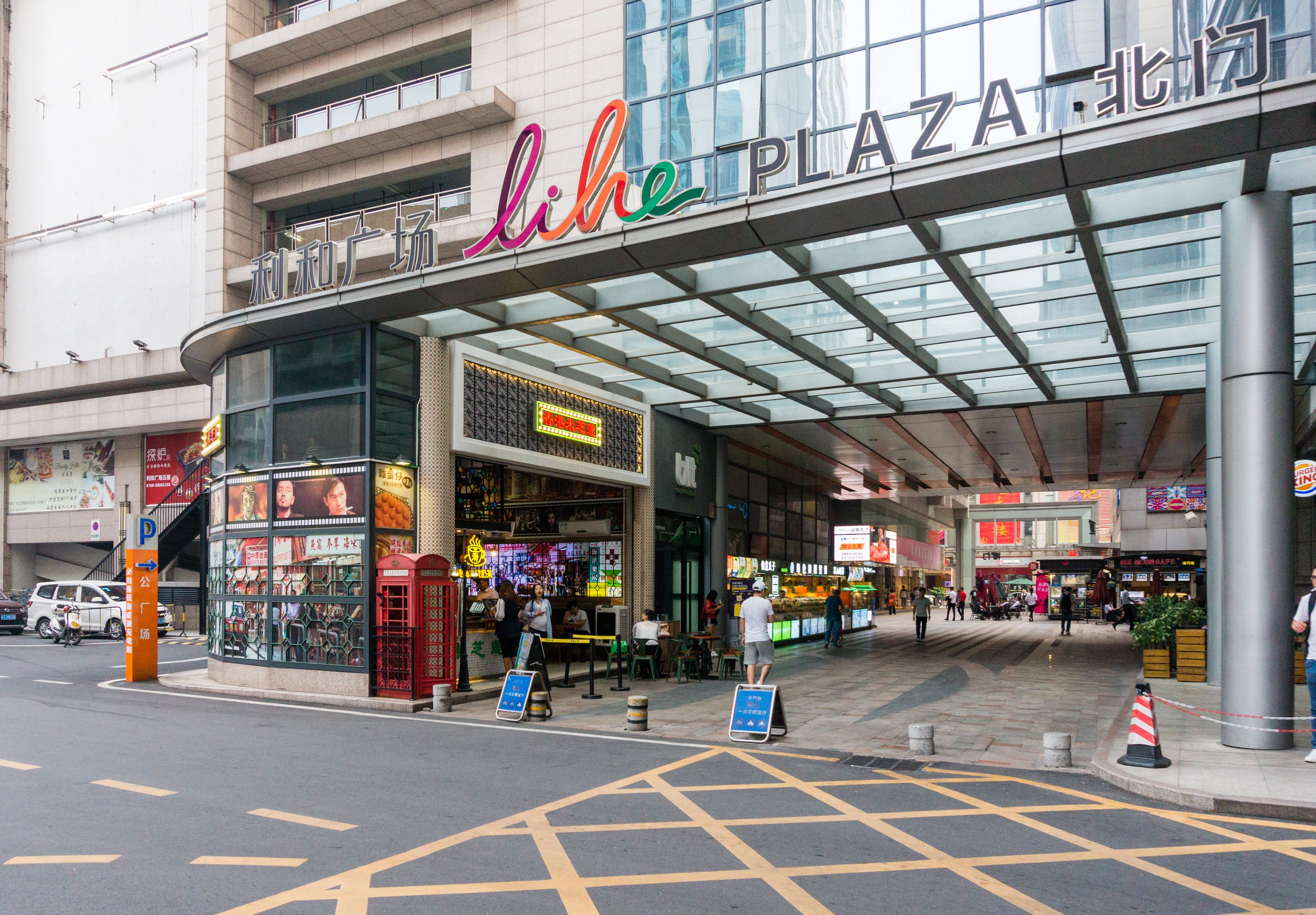 Un bâtiment moderne avec une façade en verre et une enseigne sur laquelle on peut lire « comme PLAZA ».