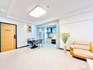 A modern hotel room with a dining area, kitchenette, and a sofa. - Yujia Aparthotel - Zhongshan Lihe Square Branch (Zhongshan)