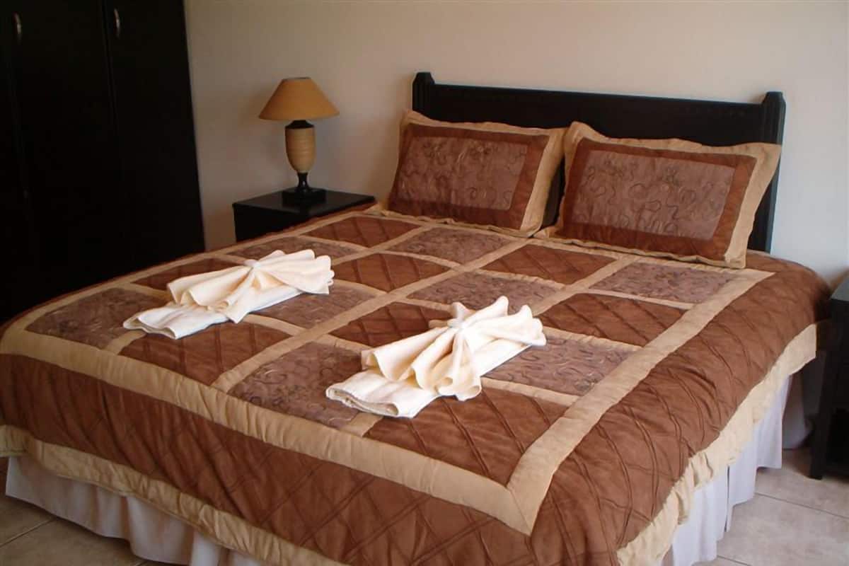 Cortinas blackout, tabla de planchar con plancha y ropa de cama