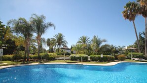 Une piscine d’eau cristalline, entourée de palmiers et d’une végétation luxuriante.