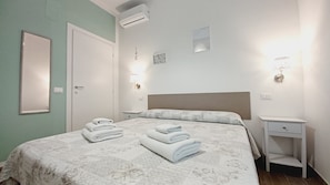 A neatly arranged bedroom with a bed, bedside tables, and a nightstand. - Il giardino (Piombino)