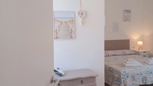 A bedroom with a bed, bedside table, and a wall-mounted picture. - Il giardino (Piombino)