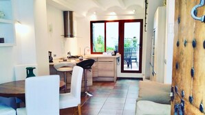 A modern kitchen with a dining area, a large window, and a view of the outdoors.